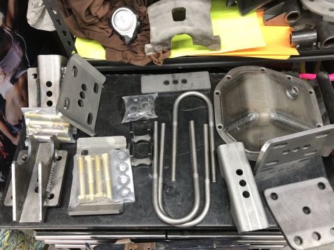 1992 Jeep Wrangler - Various Jeep Wrangler drivetrain components are laid out, including a differential cover and U-bolts.