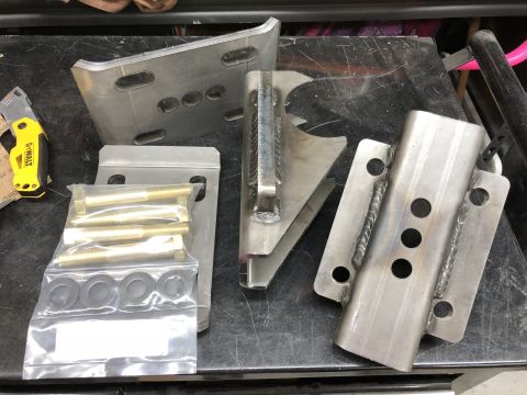 1992 Jeep Wrangler - Various metal suspension components and hardware are laid out on a dark surface.