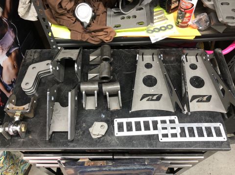 1992 Jeep Wrangler - Various metal components, likely for a vehicle's drivetrain, are arranged on a dark surface.