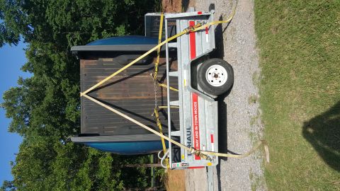 1965 Ford Mustang - A blue pickup truck bed is strapped down onto a U-Haul trailer, ready for transport.
