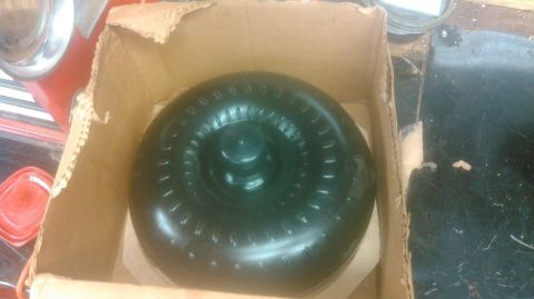 1992 Ford Bronco - A black torque converter is shown inside a cardboard box, likely for shipping or storage.