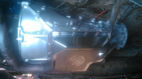1992 Ford Bronco - Underside view of an automatic transmission bolted into a truck chassis, showing the cast aluminum bellhousing, finned pan and the transfer…