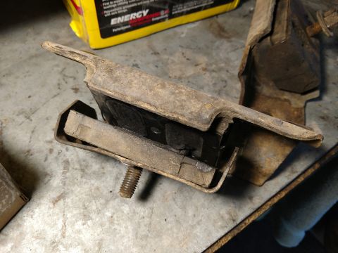 1992 Ford Bronco - Close-up of worn motor mounts, suggesting a need for replacement, with a product box visible.