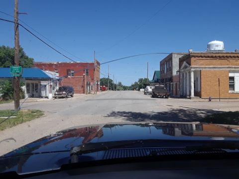 1994 Ford Bronco - A view down a small town street, with several vehicles visible and a water tower in the distance.
