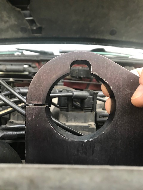 2000 Ford Explorer - A hand holds a metal engine part over the engine bay, obscuring some of the engine components.