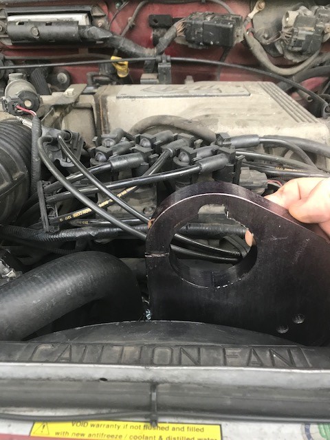 2000 Ford Explorer - Close-up of an engine bay with a hand holding a metal part near the radiator fan.