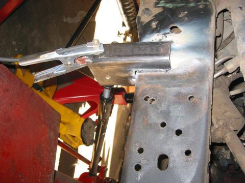 1985 Ford Bronco - Close-up of a welding clamp attached to a vehicle's frame, indicating modification work.