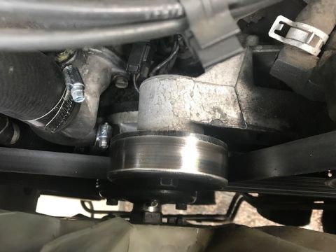 2000 Ford Explorer - Close-up view of an engine's belt and pulley system, showing various hoses and metal parts.