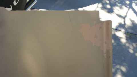 1985 Ford Bronco - A close-up of a tan interior panel shows areas where the paint is peeling, revealing a lighter color underneath.