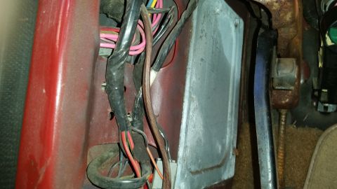 1985 Ford Bronco - A close-up view of a vehicle's interior, focusing on exposed wiring and a metal component.