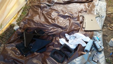 1985 Ford Bronco - Interior car parts are laid out on tarps, possibly for painting or restoration.