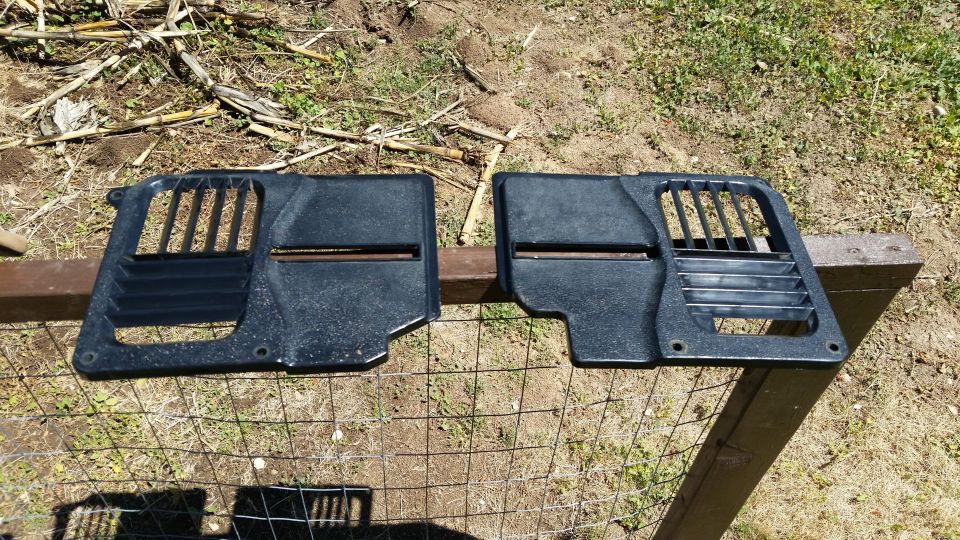two black plastic interior vent panels with horizontal slats and a grille section