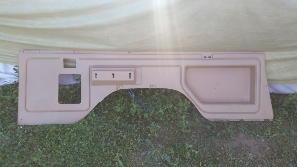 Tan interior panel with wheel well cutout and three key hooks