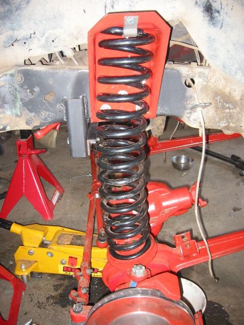 1985 Ford Bronco - This photo shows a vehicle's suspension system undergoing modification, with a focus on the coil spring and related components.