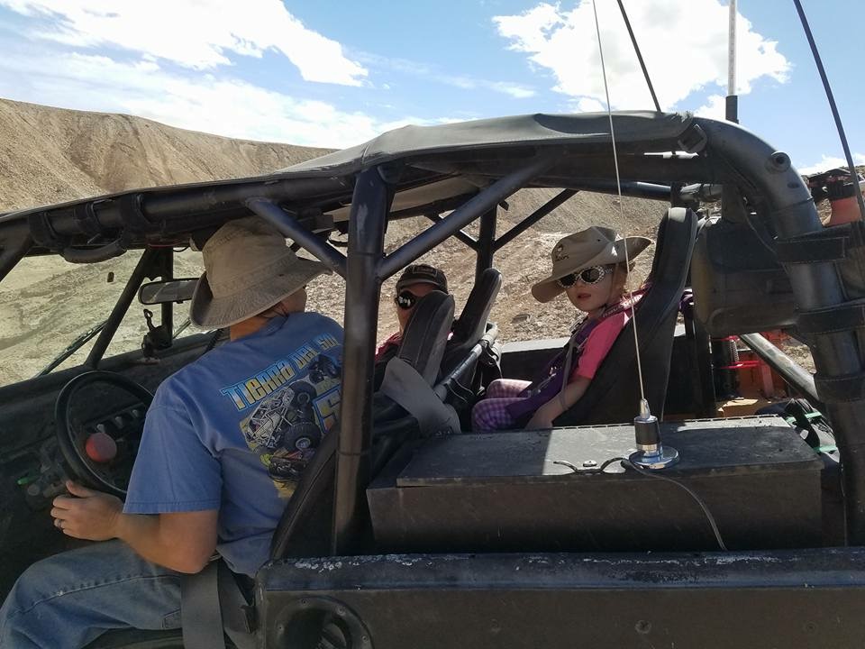 Interior view of an off-road vehicle with driver and child passengers.