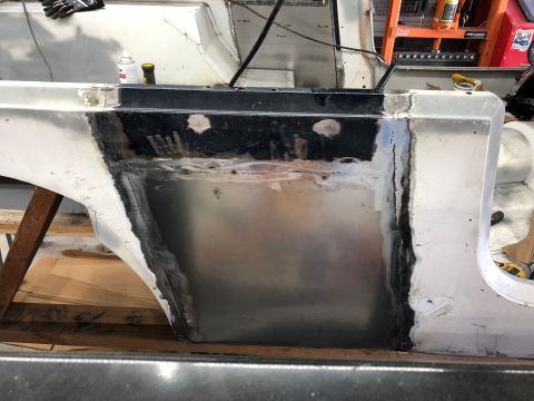 1992 Jeep Wrangler - A close-up view of a vehicle's body panel undergoing repair, showing areas of bare metal, welding, and black primer. The panel appears to b…