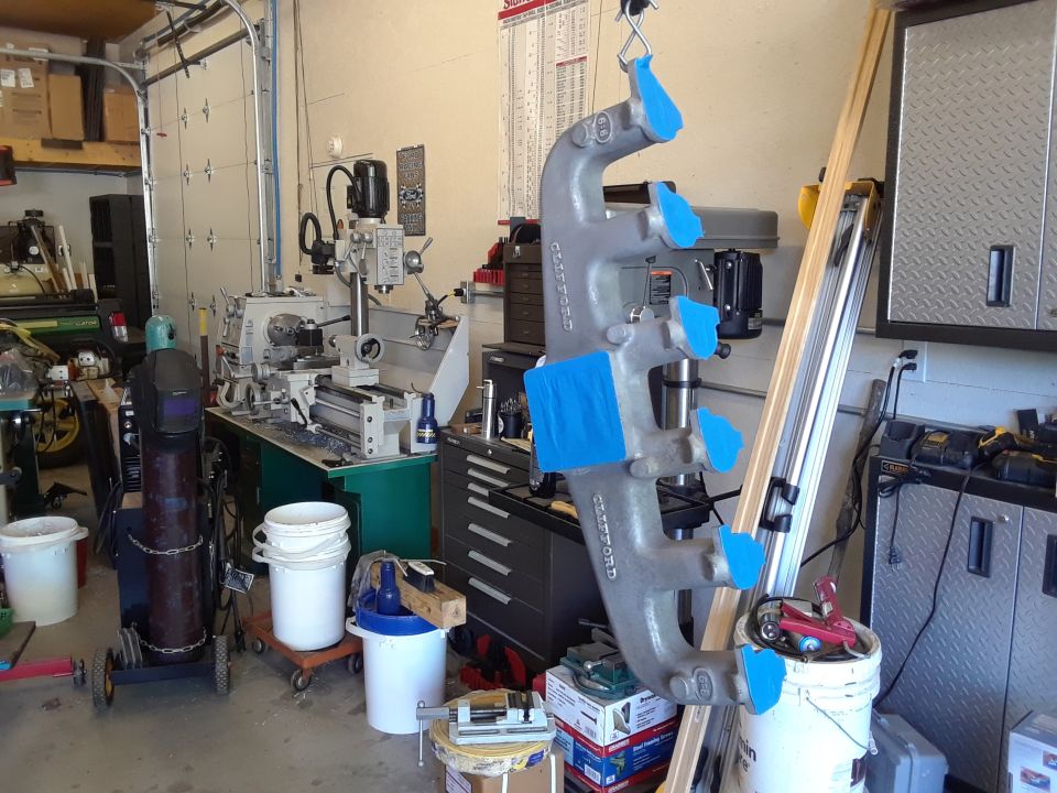 Workshop with exhaust manifold, lathe, drill press, and storage.