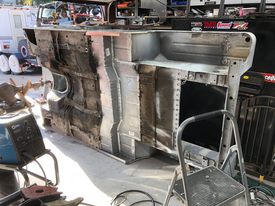 Underside of a Jeep Wrangler chassis with extensive metalwork and repairs.