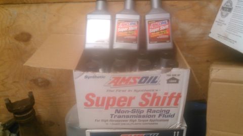 1992 Ford Bronco - A box of AMSOIL Super Shift transmission fluid is shown in a storage area with wooden walls.