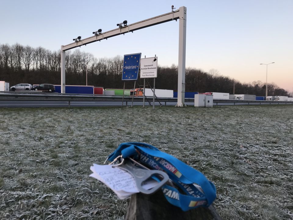 Blue lanyard with bottle opener and note on post at border crossing.