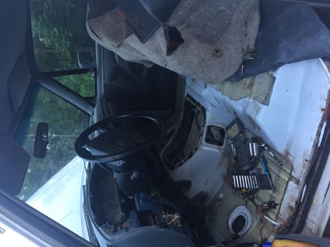 1996 Ford Bronco - The interior of a vehicle appears to be undergoing some work, with the dashboard and flooring removed. Tools are laid out on the floor, sug…