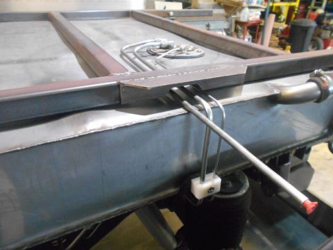 1992 Ford Bronco - A close-up view of a metal fuel tank with fuel lines and a sending unit attached. The tank appears to be part of a custom vehicle build.