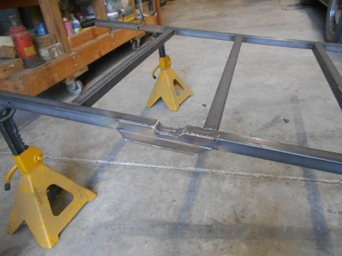 1992 Ford Bronco - A custom steel frame, likely for a vehicle project, is supported by yellow jack stands on a concrete floor. The frame appears to be constru…