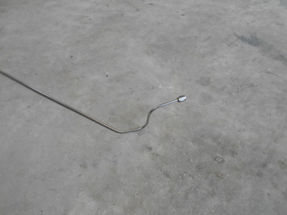 Bent metal tube with fitting on concrete