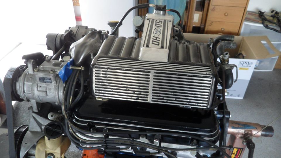 Ford 5.0 HO engine with supercharger on an engine stand.