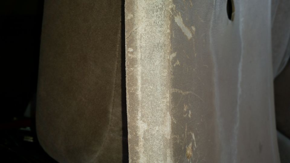 Close-up of textured interior trim panel with seam and dirt
