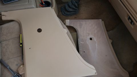 1985 Ford Bronco - Two tan interior door panels are laid out on the floor of a vehicle. One panel is lighter and appears to be a replacement, while the other…