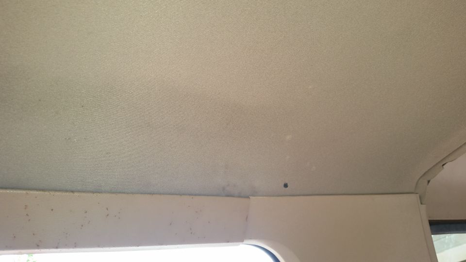 Interior headliner and trim of a vehicle with light stains.