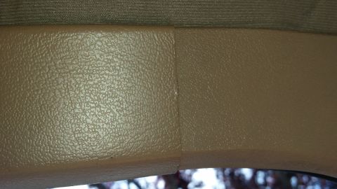 1985 Ford Bronco - A close-up view shows the textured interior trim of a vehicle, with a seam visible between two panels. Above the trim, a darker fabric is v…