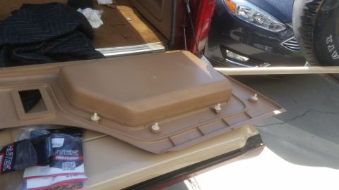 1985 Ford Bronco - A tan interior door panel with white plastic fasteners is laid out over the bed of a pickup truck. A package of "UTEX Fasteners" is visible…