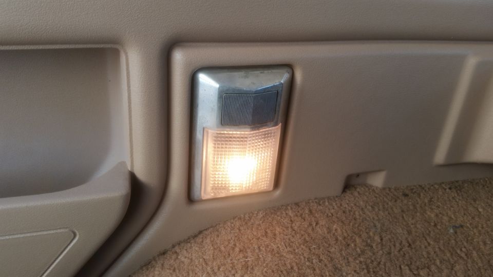 Interior dome light in tan trim above brown carpet