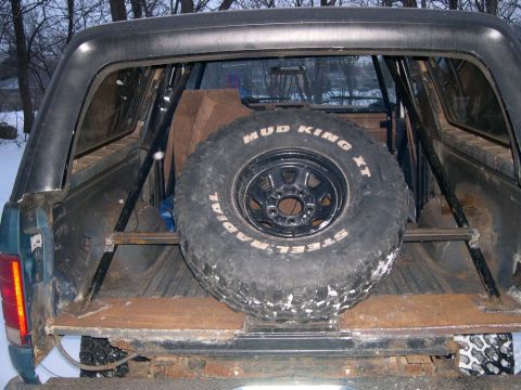 1986 Ford Bronco - Rear interior view of a 1986 Ford Bronco showing a spare tire mounted within the cargo area.