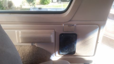 1985 Ford Bronco - Interior view of a 1985 Ford Bronco showing the rear passenger side panel with a speaker grille and a storage compartment.