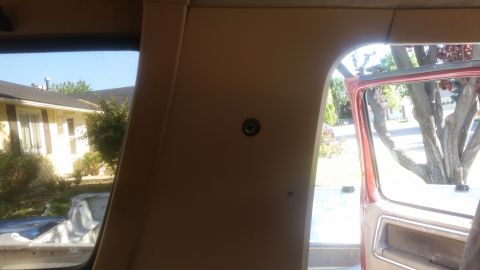1985 Ford Bronco - Interior view from the passenger side of a vehicle, looking towards the rear. A small circular fixture is visible on the tan interior panel.