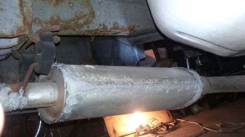 2000 Pontiac Grand Prix - The underside of a vehicle shows a muffler that appears to have been repaired with a gray sealant. The vehicle's frame exhibits significant…