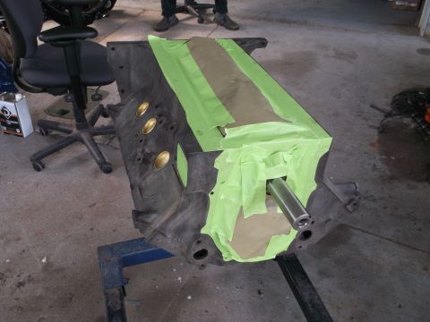 1969 Ford Mustang - Engine block prepared for work, covered in masking tape and brown paper with a metal rod in place.