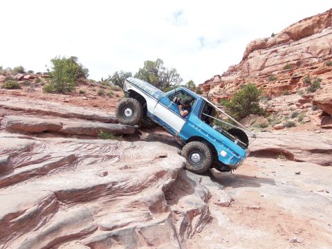 1984 Ford Bronco - This modified off-road vehicle navigates a rocky trail, demonstrating its climbing capabilities.