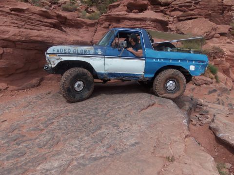 1984 Ford Bronco - This modified Ford Bronco is tackling a challenging off-road course with steep rock formations.