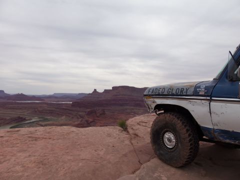 1984 Ford Bronco - A Ford Bronco, likely from the late 1970s, sits on the edge of a cliff with a scenic canyon view.