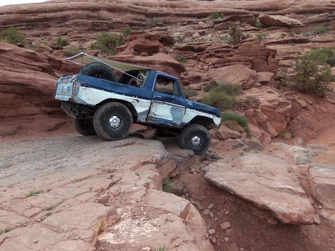 1984 Ford Bronco - This modified Ford Bronco navigates a rocky trail, showing its off-road capabilities.