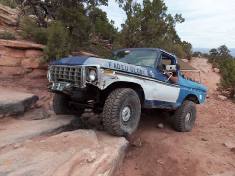 1984 Ford Bronco - This Ford Bronco is tackling a challenging off-road trail with large rocks.