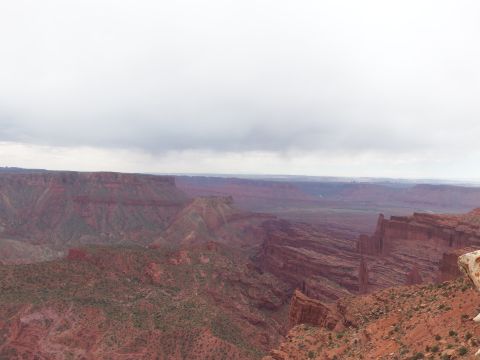 1984 Ford Bronco - A vast canyon landscape unfolds under a dramatic sky, the grandeur of the natural terrain.