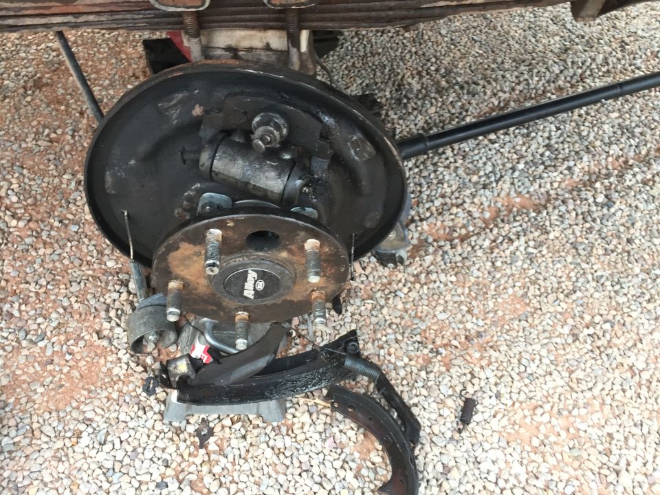 Disassembled drum brake assembly with brake shoes and wheel cylinder visible. Supermotors.net logo in lower right