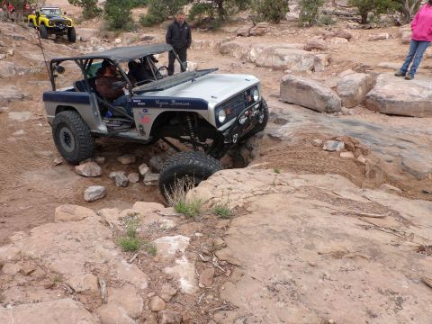 1984 Ford Bronco - Modified off-road vehicle navigating a challenging rocky trail with another vehicle in the background.