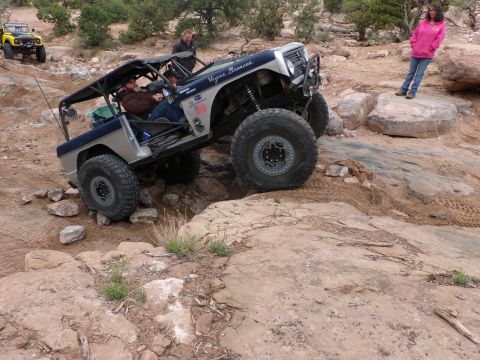 1984 Ford Bronco - This heavily modified SUV navigates a rocky trail, with another vehicle visible in the background.