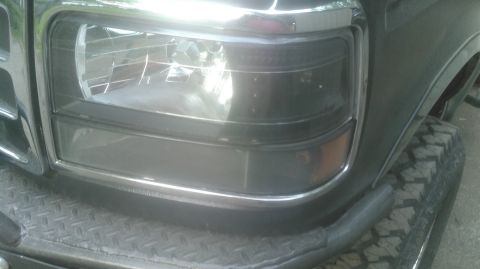 1992 Ford Bronco - Close-up of the front headlight and grille of a 1992 Ford Bronco.
